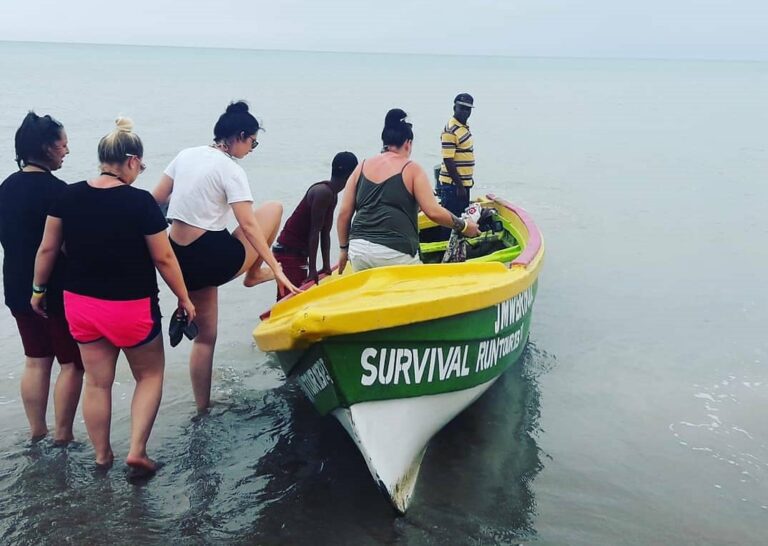 Group of female visitors climbing into a local fishing boat while the boat captain stands onboard, preparing to take them to the Pelican Bar.