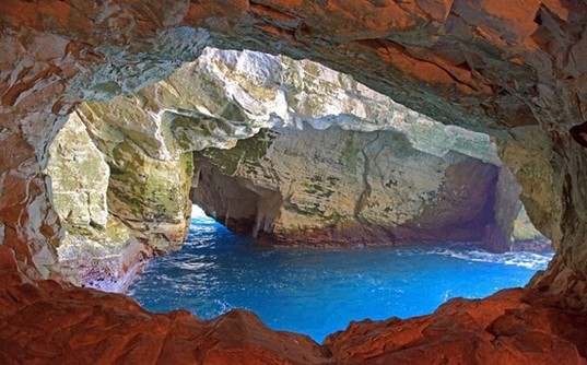 Opening inside the Green Grotto Caves where deep blue Caribbean Sea water flows through a massive rock passage leading directly out to the open sea.