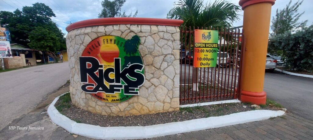 Rick’s Café logo sign displayed on the wall at the property entrance in Negril, Jamaica.