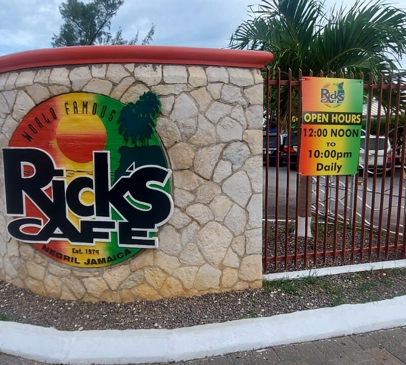Rick’s Café logo sign displayed on the wall at the property entrance in Negril, Jamaica.
