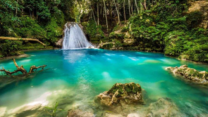 Blue Hole river stretching from its vibrant turquoise waters at one end up to the cascading falls at the other
