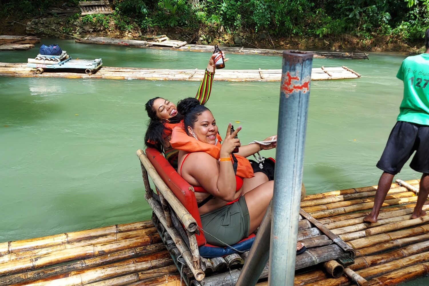 2 women on a bamboo raft drinking Bear