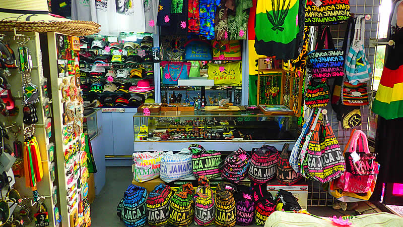 Local duty-free shop on Montego Bay Hip Strip with colorful t-shirts, souvenirs, and assorted merchandise displayed inside.
