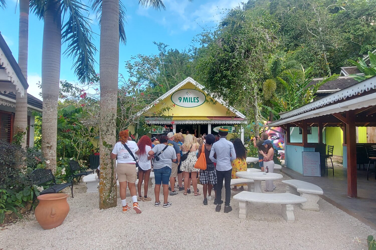 A group of visitors walk toward a building marked with a Nine Mile sign at the Bob Marley attraction in Jamaica.