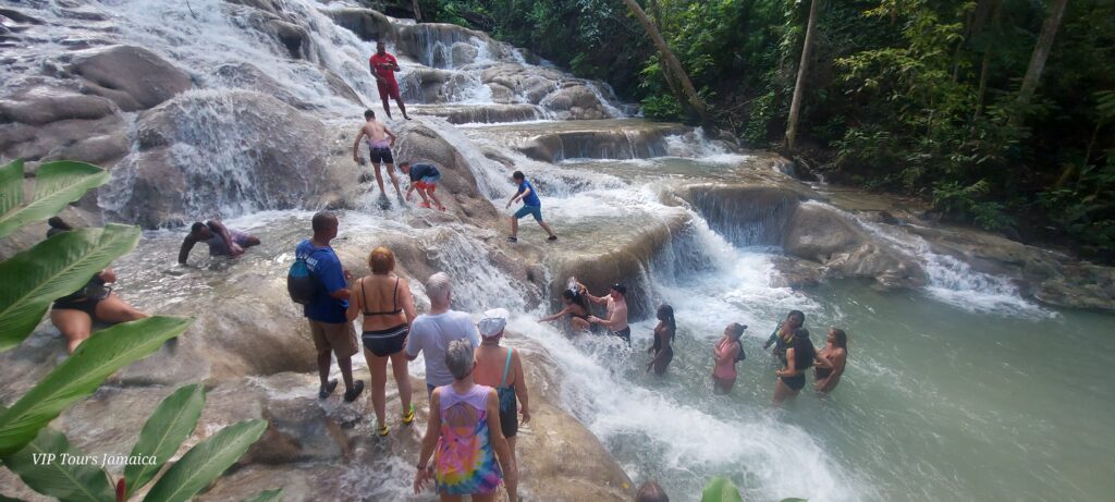 People standing on huge rocks with water flowing over it