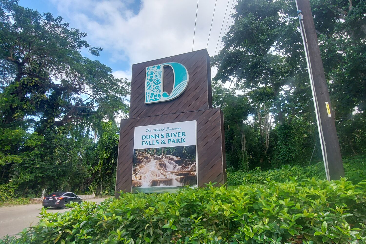 A brown sign board with the letter D in blue and white