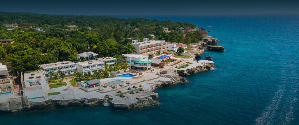 Beaches Negril Resort featuring tropical gardens, shimmering pools, and the Caribbean Sea under sunny skies.