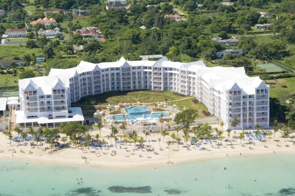 Riu Ocho Rios Resort with palm trees, pool, and ocean view.
